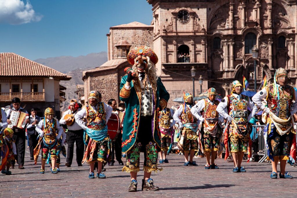 Colorful dancers in traditional costumes parade through Cusco, showcasing rich cultural heritage.